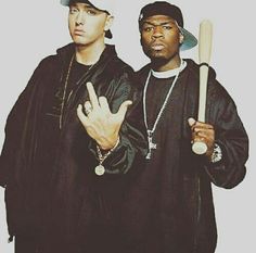 two men standing next to each other with baseball bats in their hands and one holding a peace sign