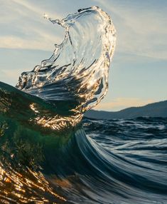 the water is splashing on top of the wave