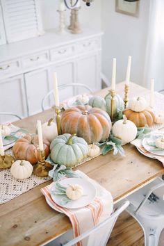 a wooden table topped with lots of pumpkins and other decorations on top of it