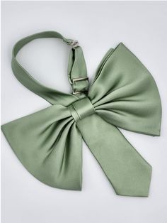 Our newest most demure bow, the Jenny is crafted in beautiful silk and will add the classiest touch to any spring look. This sage green colour will be the final spring touch on top of any outfit, and the fabric gives a more relaxed appearance. Like all our styles, the Jenny is pretied, with an adjustable neck band to give the desired fit, so it can lay perfectly on the side of your neck. Style over a simple blouse for a sophisticated look, and let the tie speak for itself. Or layer over a stunni Chic Satin Bow For Spring, Chic Satin Bow For Formal Occasions, Spring Party Bow With Ties, Silk Bow With Detachable Bow For Formal Occasions, Silk Bow With Detachable Detail For Formal Occasions, Spring Black Tie Satin Bow, Detachable Bow For Spring Wedding, Spring Formal Bow Tie With Satin Bow, Formal Silk Bow With Detachable Feature