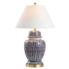 a blue and white table lamp with a white shade on the top, sitting against a white background