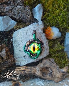 a green and yellow pendant sitting on top of a rock