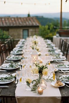 a long table is set with plates and candles