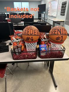 two basketballs sitting on top of each other in front of a desk with snacks