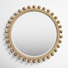 a round mirror with wooden beads on it