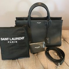 Sleek Saint Laurent Leather Satchel With Slender Top Handles, Removal Adjustable Strap And Dangling Ysl Log Tag. Bag Comes With Original Dust Bag. Pretty Much Like Brand New! Bag Was Loved And Only Worn A Hand Full Of Times. Top Zip Closure, Exterior Wall Pocket, Interior Zip Wall And Smartphone Pockets, Protective Metal Feet, Calfskin Lining (Gorgeous Inside And Out). Designer Double Handle Satchel For Everyday Luxury, Designer Satchel With Top Carry Handle For Everyday Luxury, Designer Satchel For Everyday Luxury, Luxury Everyday Satchel With Dust Bag, Black Satchel With Palladium Hardware For Everyday Luxury, Elegant Black Briefcase With Dust Bag, Designer Black Briefcase With Handle Drop, Tot Bag, Bag Ysl