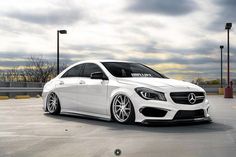 a white mercedes cla parked in a parking lot