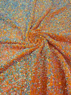 an orange and blue colored fabric with sprinkles on the bottom, as seen from above