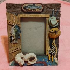 an old photo frame is decorated with fishing related items, such as fish and lures