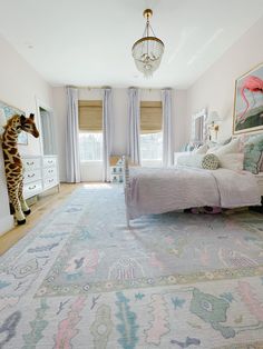 a bed room with a neatly made bed and a giraffe statue