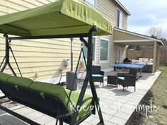 a patio with a swing chair and table