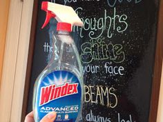 a hand holding a bottle of windex all purpose cleaner in front of a chalkboard