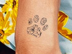 a person with a tattoo on their arm that has a dog's paw in it