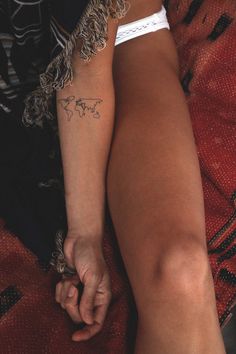 a woman with tattoos on her arm and leg