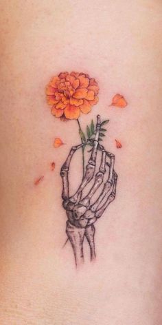 a woman's stomach with an orange flower in her hand and petals coming out of it