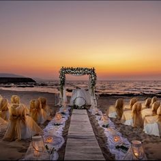 an outdoor wedding setup on the beach at sunset