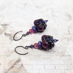 "These violet pink earrings feature lampwork beads made by Katerina Sojkova. Main beads feature lavender plunged flowers in fuchsia glass as well as swirls of green, violet and silver raised dots. I have added lavender accent lampwork beads, pink and violet crystals and silver-filled handmade gunmetal earwires. Earrings measure 2\" long. Please see my shop policies for more information: http://www.etsy.com/shop/milminedesign/policy How to care for your jewelry: To keep your jewelry looking great, please store in a sealed, air-tight zip lock bag. Do not use while swimming or bathing. Lotions and perfume may cause discoloration of the metal." Purple Czech Glass Jewelry With Dangling Beads, Lamp Work Bead Jewelry, Lampwork Bead Necklace, Glass Bead Earrings, Lampwork Jewelry, Lampwork Earring, Lampwork Focal Bead, Handmade Glass Beads, Pink Earrings