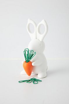 a small white rabbit holding a carrot