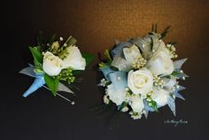 two bridal bouquets sitting on top of a table next to each other in front of a wall