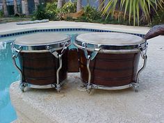 two wooden drums sitting next to a swimming pool