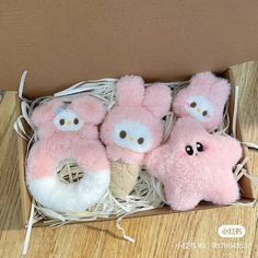 three pink stuffed animals in a box