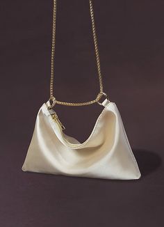 a white purse on a gold chain