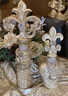 an ornate vase with flowers in it sitting on a table cloth covered tablecloth next to other decorative items