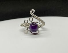 Adjustable Size Sterling Silver wire wrapped Ring with Amethyst. Adjustable from size 7-11. Amethyst is one of the most famous and prominent crystals because of its beautiful coloration as well as its spiritual and literal meaning. The spiritual meaning of Amethyst is groundedness, tranquility, and calm. Adjustable Wire Wrapped Sterling Silver Crystal Ring, Adjustable Sterling Silver Wire Wrapped Crystal Ring, Unique Adjustable Amethyst Promise Ring, Adjustable Hand Wrapped Sterling Silver Rings, Adjustable Purple Amethyst Crystal Ring, Adjustable Purple Amethyst Ring, Handmade Adjustable Amethyst Crystal Ring, Adjustable Purple Amethyst Ring Gift, Handmade Adjustable Amethyst Ring