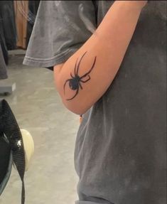 a man with a spider tattoo on his arm