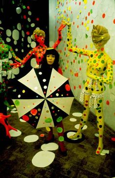 two mannequins dressed in polka dot clothing and holding an umbrella