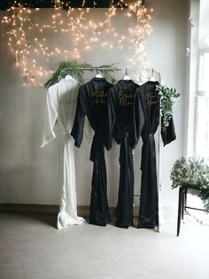 Our long black bridesmaid robes are not just elegant; they're personalized satin robe beauties. Ideal custom gifts for the cherished ladies in your life--mother of the bride and mother of the groom included. These bridal party robes are a hit, whether for the bride herself or as a thoughtful gift for her. And let's not forget the flower girl proposal--adorable robes for the youngest members of your special day. From bridal shower gifts to making your ladies feel fabulous, these robes for women a Black Robes For Bridesmaids, Black Bridesmaids Robes, Black Bridal Robe, Wedding Robes Bridesmaids Black, Bride And Bridesmaid Robes Black, Elegant Black Silk Robe, Bridesmaid Robe Personalized, Satin Bridesmaids Robes, Personalized Robe