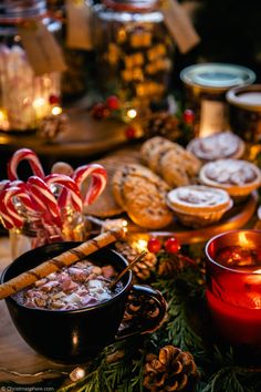 a table topped with lots of food next to candles and candy canes on top of it