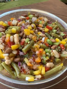 a glass bowl filled with beans and veggies