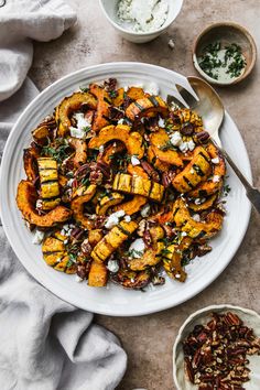 a white plate topped with roasted squash and pecans