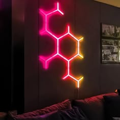 a living room filled with lots of furniture and neon lights on the wall above it