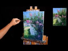 a person is painting flowers on an easel