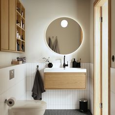 a bathroom with a round mirror above the sink and toilet next to it is shown