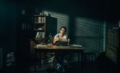 a man sitting at a desk in the dark