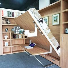 a laptop computer sitting on top of a desk in a room with bookshelves