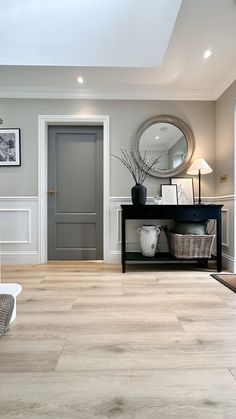 a living room filled with furniture and a large mirror on the wall next to a door