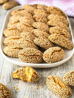 sesame seed bagels in a white dish on a wooden table