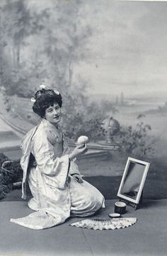 an old photo of a woman sitting on the ground with something in front of her