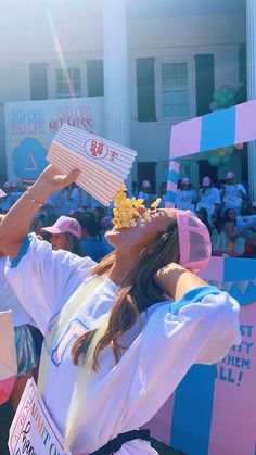 a woman in a white shirt and pink hat is holding up signs with flowers on them