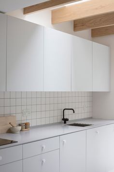 a kitchen with white cabinets and counter tops