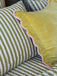 a green and white striped bed with pillows