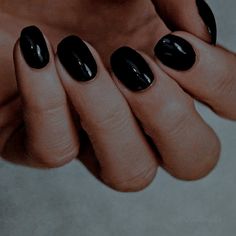 a woman's hand with black nail polish on it