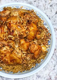 a plate full of chicken and rice on a table