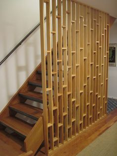 a wooden stair case next to a hand rail