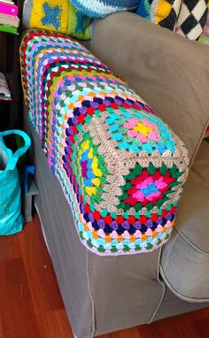 a crocheted granny blanket is on the back of a couch