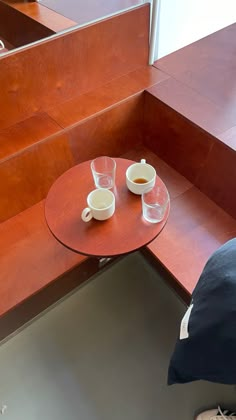 two cups of coffee sit on a red table